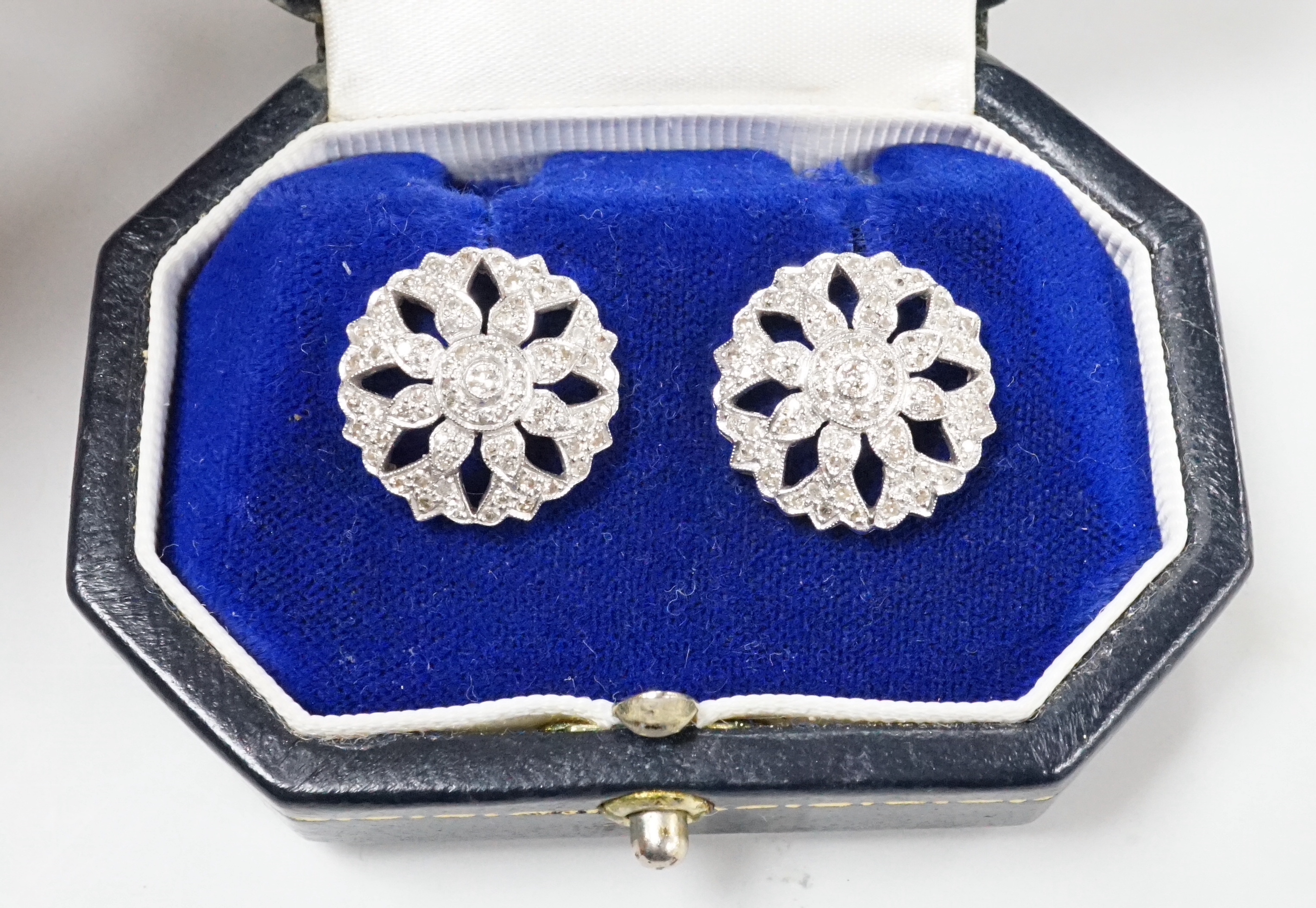 A pair of pierced white metal and diamond set circular cluster earrings, diameter 17mm, with 925 butterflies, gross weight 6.7 grams.